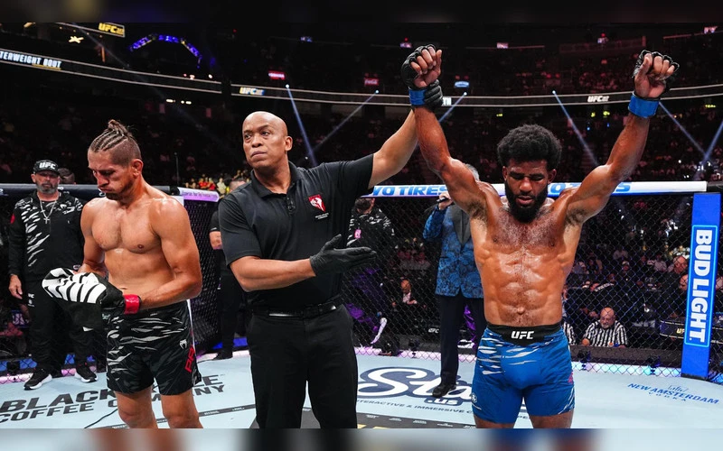 Jacobe Smith celebrates a UFC victory as the referee raises his hand inside the Octagon